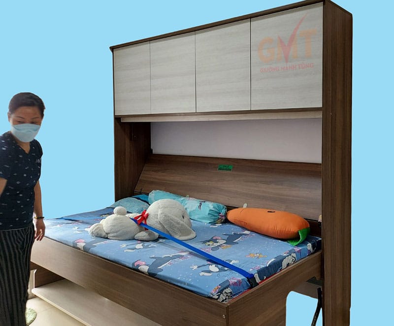 Người phụ nữ bên giường gấp thông minh kết hợp bàn học đang mở