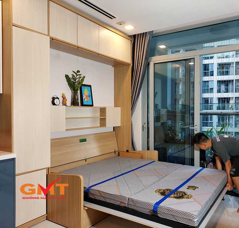 Một người đàn ông đang gấp giường gấp thông minh có tích hợp tủ kệ, để tham khảo báo giá giường gấp thông minh mới nhất.