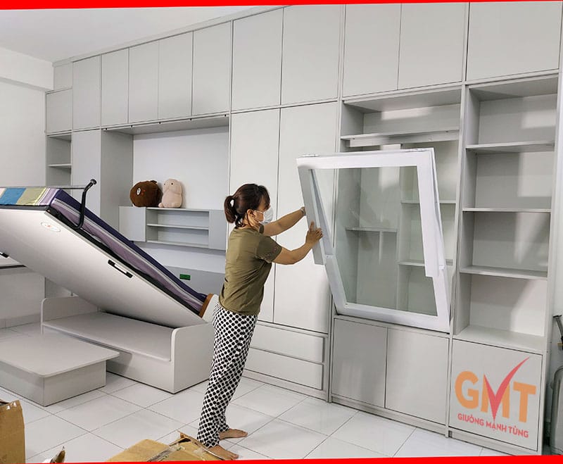 Hình ảnh minh họa báo giá giường gấp thông minh của Mạnh Tùng, với người phụ nữ đang thao tác mở tủ kệ.