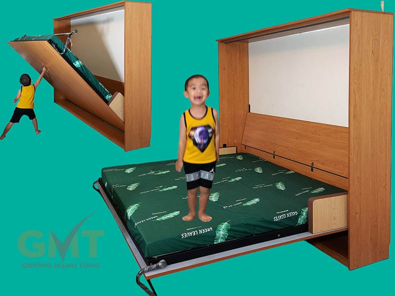 Giường ngủ gấp thông minh màu vân gỗ đang được mở ra, với bé trai đứng trên nệm và thao tác thử cơ chế gấp mở an toàn.